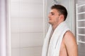Young man holding towel on his shoulders after washing procedure Royalty Free Stock Photo