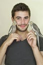 Young man holding two parrots Royalty Free Stock Photo