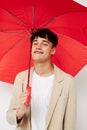 A young man holding an umbrella in the hands of posing fashion light background unaltered Royalty Free Stock Photo