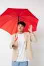 A young man holding an umbrella in the hands of posing fashion light background unaltered Royalty Free Stock Photo