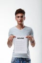 Young man holding up a blank document with title - Resume Royalty Free Stock Photo