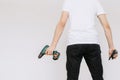 A young man holding a walkie-talkie and a drill, a screwdriver. Isolated white background Royalty Free Stock Photo