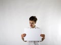 Young man holding white paper in his hands. Crazy. Royalty Free Stock Photo