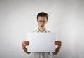 Young man holding white paper in his hands. Sad and bored man. Royalty Free Stock Photo