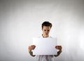 Young man holding white paper in his hands. Unhappy. Royalty Free Stock Photo