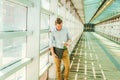 Young man holding white rose, standing on walkway, thinking