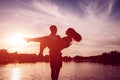 Young man holding woman on summer river bank. Couple having fun at sunset. Guys chilling Royalty Free Stock Photo