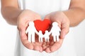 Young man holding wooden  figure and red heart on white background, closeup of hands Royalty Free Stock Photo