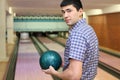 Young man holds ball for bowling