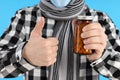 Young man holds bottle with pills on blue background Royalty Free Stock Photo