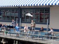 Young man holds bread in mouth so seagull can grab it out