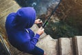 Young man holds a fishing rod and catches fish in the nature on a sea background, hipster fisherman spends vacation on the blue Royalty Free Stock Photo