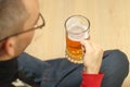 a young man holds a full mug of beer in his handr