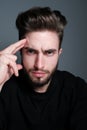 A young man holds his head and shows different human emotions: hatred, fear, despair, horror, malaise, headache, clairvoyance.