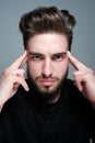 A young man holds his head and shows different human emotions: hatred, fear, despair, horror, malaise, headache, clairvoyance.