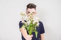 A young man holds out a bouquet of white flowers Royalty Free Stock Photo