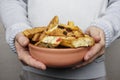 A young man holds a plate with homemade cookies with raisins, chocolate, nuts. Breakfast. Close.