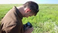 A young man holds the remote control of the drone in his hands and controls it