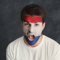 Young man with Holland flag painted on his face