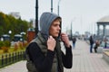 Young man in a hood on the embankment. Rotunda and street lamps. Blur the background. Royalty Free Stock Photo