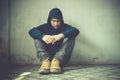 Young man in hood sitting in room corner. Royalty Free Stock Photo