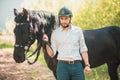 Young man with horse. Autumn outdoors scene Royalty Free Stock Photo