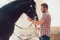 Young man with horse. Autumn outdoors scene Royalty Free Stock Photo