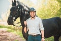 Young man with horse. Autumn outdoors scene Royalty Free Stock Photo