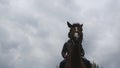 Young man horseback riding outdoor. Male jockey riding a horse on dark cloudy day. Beautiful rainy sky at background Royalty Free Stock Photo