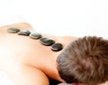 Young man with hot stones in a spa center Royalty Free Stock Photo