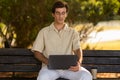 Young man independent contractor sitting on bench, using laptop computer Royalty Free Stock Photo