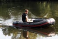 Young man in inflatable boat with fishing at river. Royalty Free Stock Photo