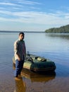 Young man in an inflatable boat on the lake, resting. the man using the smartphone Royalty Free Stock Photo
