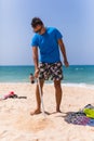 Young man install in sand solar umbrella on a beach Royalty Free Stock Photo