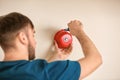 Young man installing alarm bell on wall Royalty Free Stock Photo