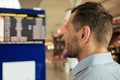 A young man at an international airport looks at a flight information board, checks his flight Royalty Free Stock Photo