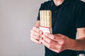 Young man isolated over background. Cut view of guy holding chocolate bar in hands and show it on camera. Tasty Royalty Free Stock Photo