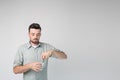 Young man isolated over background. Guy in shirt hold glass of water in hand and pouring powder into it. Calm peaceful Royalty Free Stock Photo