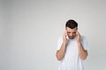 Young man isolated over background. Headache or thinking. Calm peaceful guy in studio stand alone and look down. Royalty Free Stock Photo