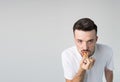 Young man isolated over background. Strange weirdo look straight on camera and biting piece of yummy tasty burger. Guy Royalty Free Stock Photo