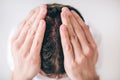 Young man isolated over white background. Close up picture of head. Hair problem falling down. Hold hands on head