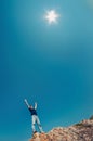 Young man in jeans and black shirt on a mountain raised their h Royalty Free Stock Photo