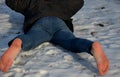 Young man in jeans running away barefoot in the snow. Detained by police lying on the ground with his hands behind his back, no sh