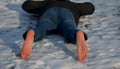 Young man in jeans running away barefoot in the snow. Detained by police lying on the ground with his hands behind his back, no sh