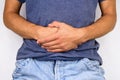 young man in jeans and t-shirt holds hands to his stomach