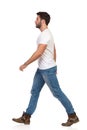 Young Man In Jeans And White T-shirt Is Walking Side View