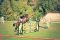 Young man jockey ride beautiful brown horse and jump over the crotch in equestrian sport closeup.