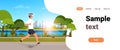 Young man jogging outdoors modern public park guy in headphones running sport activity concept cityscape sunset Royalty Free Stock Photo