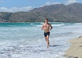 Young man jogging on the sea beach Royalty Free Stock Photo