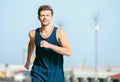 Young man jogging at the street in summer morning time